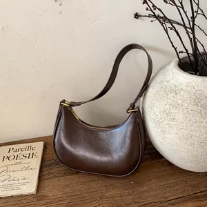 Détails de ce sac hobo croissant café foncé, texture cuir vintage et boucles dorées