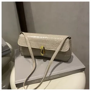 Close-up of beige crocodile pattern texture and gold oval metal clasp on handbag