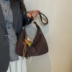 Retro dark brown hobo bag with a cute bear charm and a wide strap for daily commute