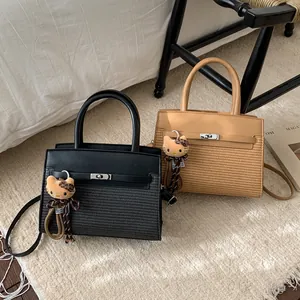 Detail view of contrast stitching and woven texture on a stylish leather flap handbag