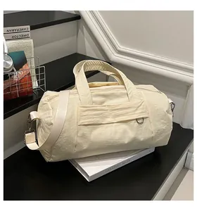 Nahaufnahme der beigen Nylontasche mit Crinkle-Struktur und Metall-D-Ring-Detail
