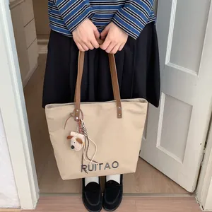 Détail du sac cabas en toile avec broderie RUITAO et breloque en peluche pour chiot