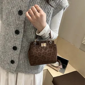 Mini sac seau à imprimé léopard avec boucle dorée présenté avec tenue chic