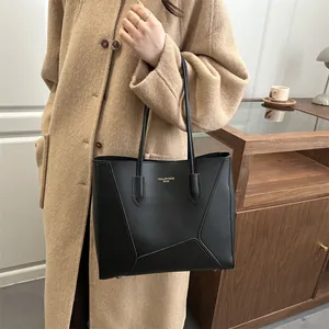 Classic black leather tote bag with geometric stitching and slim shoulder straps for commuting