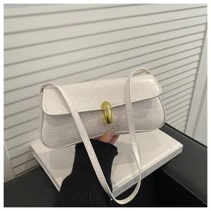 Close-up of white crocodile pattern leather texture with golden metal twist lock detail