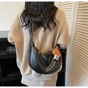 Sac à bandoulière croissant noir moderne avec breloque ours en peluche sur le modèle