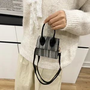 Ethnic woven mini crossbody bag in grey and black pattern with top handles and strap
