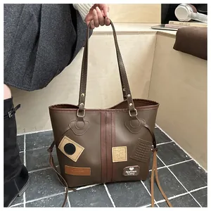Close-up of vintage-style patchwork and fashion lucky emblems on a brown leather tote bag