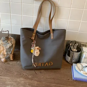 Détail du sac cabas en toile avec broderie RUITAO et breloque chien en peluche