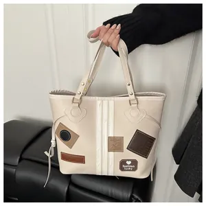 Detail of off-white tote bag with trendy colorful patches and gold metal hardware