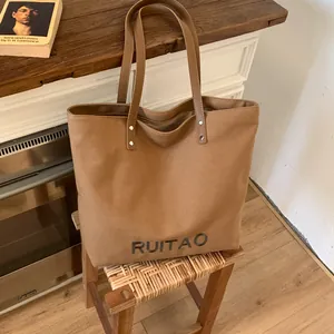 Détail du sac cabas en toile marron avec broderie RUITAO et poignées en cuir
