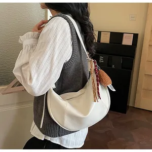 Vue détaillée du sac croissant blanc avec pendentif en peluche et corde tressée
