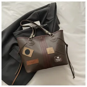 Detail of dark coffee tote bag featuring stylish leather patches and side drawstring accents