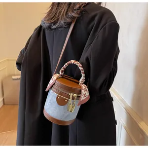 Detail of vintage bucket bag with silk-wrapped handle and denim leather patchwork design