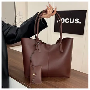 Detailed shot of dark burgundy leather tote bag with matching mini envelope pouch