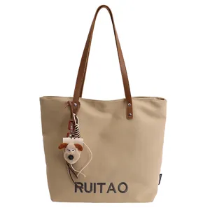 Sac fourre-tout en toile beige avec anses en cuir marron et breloque chiot