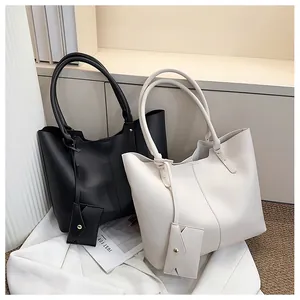Detail of minimalist tote bags in black and beige with matching envelope pouches