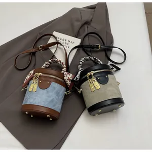 Detail of color-block bucket bags with silk scarf handles and gold lock charms