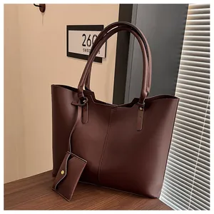 Close-up of deep brown tote bag with matte texture and small matching pouch attachment