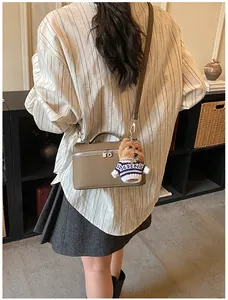 Bolso caja de cuero taupe granulado con herrajes plateados y colgante de perrito