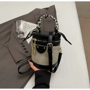 Detail of grey canvas bucket bag with black leather trim and silk scarf on the handle