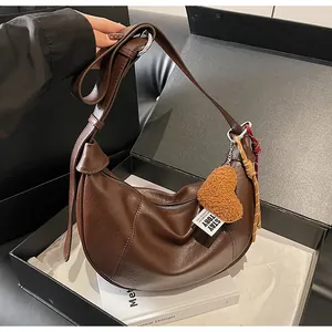 Détails du sac croissant avec breloque cœur en peluche et sangle tressée décorative