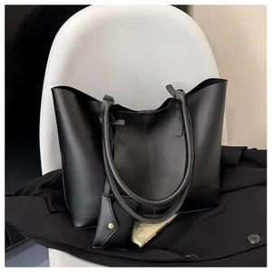 Close-up of black matte PU leather tote bag with a small detachable coin purse on a chair