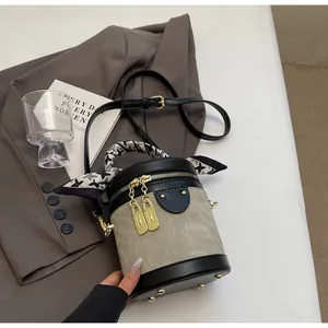 Detailed top view of grey and black contrast bucket bag with silk scarf on handle