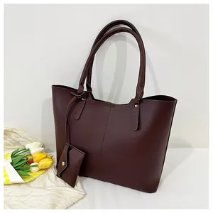 Deep burgundy tote bag detail with matching mini coin purse and silver rivet reinforcements