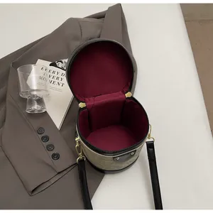 Detail view of bucket bag showing deep red lining and spacious interior with dual zippers