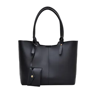 Minimalist black tote bag with matching pouch and slender shoulder straps on white background