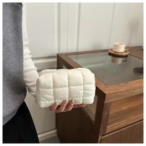 Detail of a beige quilted cosmetic bag with soft padded fabric and zipper closure