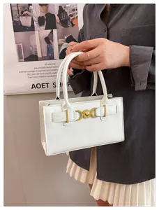 Detail of white structured handbag featuring a gold heart clasp and premium leather finish