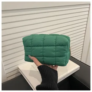 Détail de la trousse de toilette matelassée verte avec motif à carreaux et zip doré