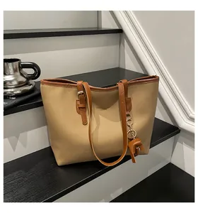 Macro-opname van khaki lederen shopper met bruine riemen en olifant hanger op een trap