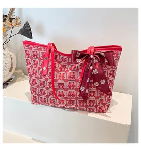Détail du sac cabas tissé rouge et blanc avec motif Double Bonheur et nœud en soie