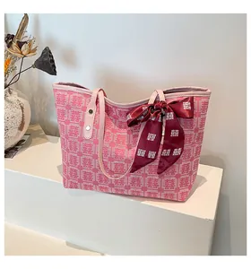 Détail du sac cabas rose tissé avec motif Double Bonheur rouge et nœud en soie décoratif