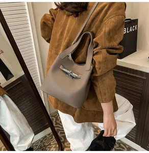 Détail du sac seau taupe avec texture grainée litchi et boucle en métal élégante