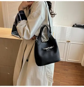 Détail de la texture cuir noir grainé et de la boucle métallique argentée du sac