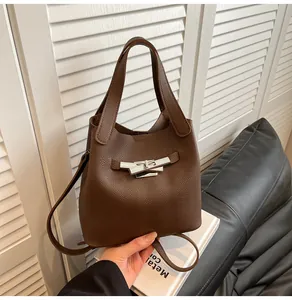 Détail du sac seau en cuir grainé marron foncé avec fermeture à boucle en métal argenté