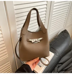 Détail du sac seau en cuir grainé gris éléphant avec boucle de ruban en métal argenté