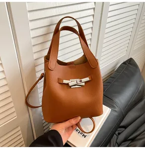 Gros plan du sac seau en cuir grainé marron avec boucle argentée et cordon de serrage