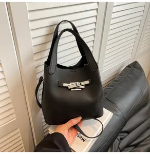 Gros plan du sac seau en cuir grainé noir avec détails de boucle rotative en métal argenté