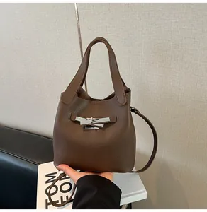 Détails du sac seau en cuir grainé marron foncé avec fermoir rotatif argenté et poignées