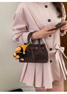 Retro brown canvas bucket bag detail with a cute monkey charm and leather strap