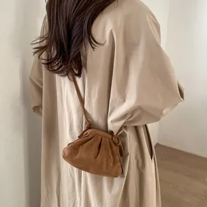 Détail d'un sac à main plissé marron avec texture daim douce et une fine bandoulière élégante
