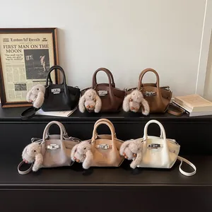 Minimalist bucket bag in various colors featuring lychee leather and bunny charm