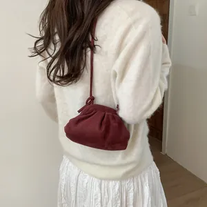 Détail du sac dumpling bordeaux avec texture velours plissée et fine bandoulière corde