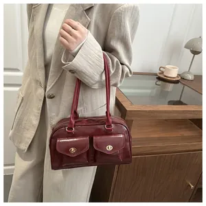Detail of dark red vintage pillow bag featuring double front pockets and gold turn-locks