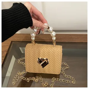 Detail of woven texture, pearl handle and golden heart lock on stylish straw bag